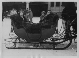 Clara Bow, Mrs, Knoph, Mrs. Goulding and Vilma Banky in a sled at St. Mortiz, Switzerland. Labeled on back: Film Stars Enjoy the Winter Sports at St. Mortiz, Switzerland.  Left to right, left seat: Clara Bow, the famous "It" girl of the screen and Mrs. Knoph.  Left to right seat: - Mrs. Goulding and Vilma Banky, the firlm star, off for a sleigh ride.  S. & G. 11-1-33. Copyright stamp on back: Sport & General Press Agency, Limited. London. Copyright