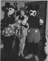 Clara Bow in costume for a 1933 Hollywood party with two unidentified people dressed as Mickey and Minnie Mouse in an unknown location