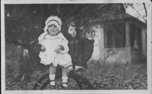 Photograph of two young children (Frankie and Beverly) on a chair.  Back of image is a postcard with handwritten text:"Frankie and Beverly" and other unidentifiable words