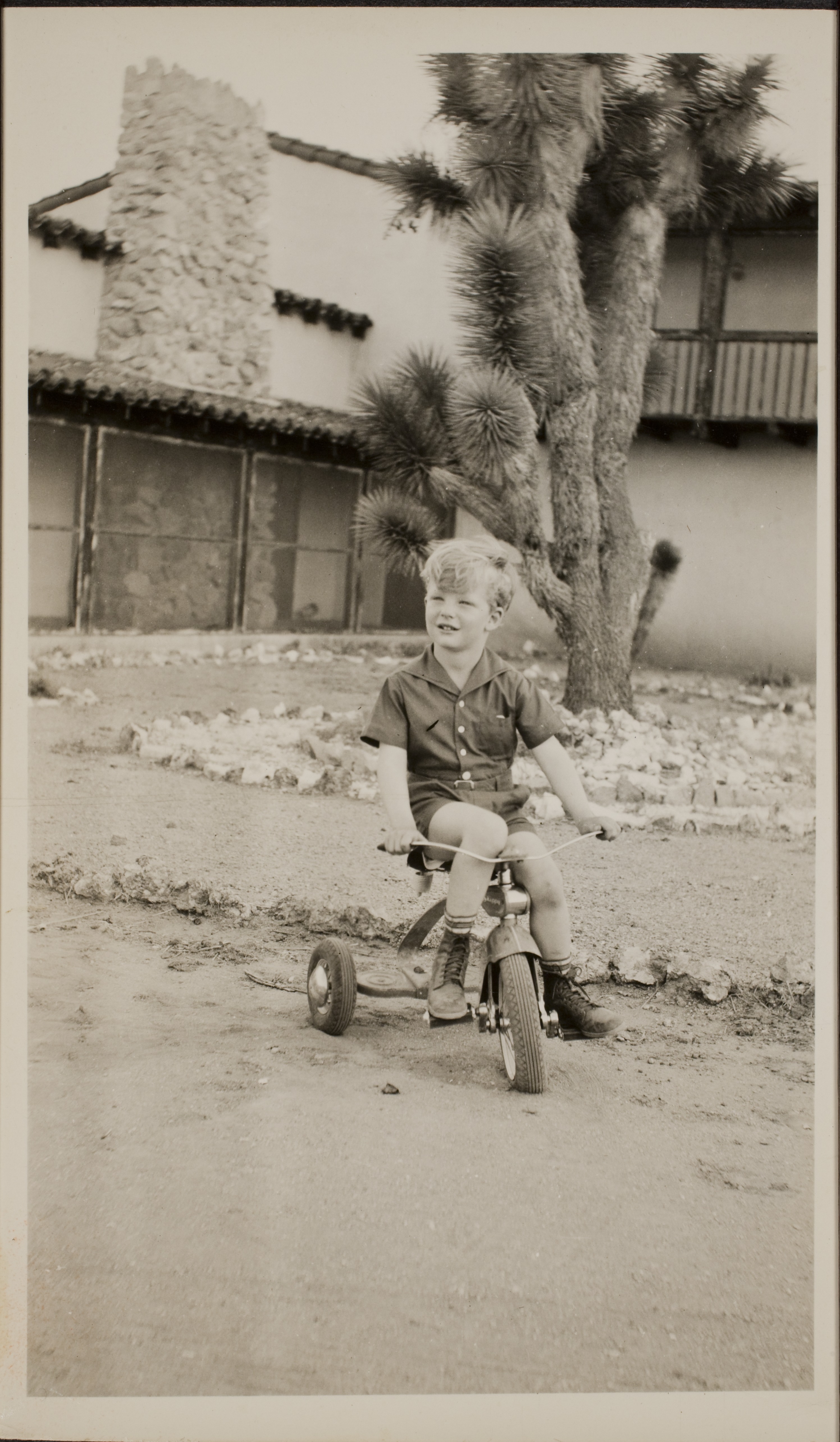 Rex Anthony Bell, Jr (Toni Larbow Beldam) at Walking Box Ranch, Nevada riding a tricycle in front of the ranch house: photographic print