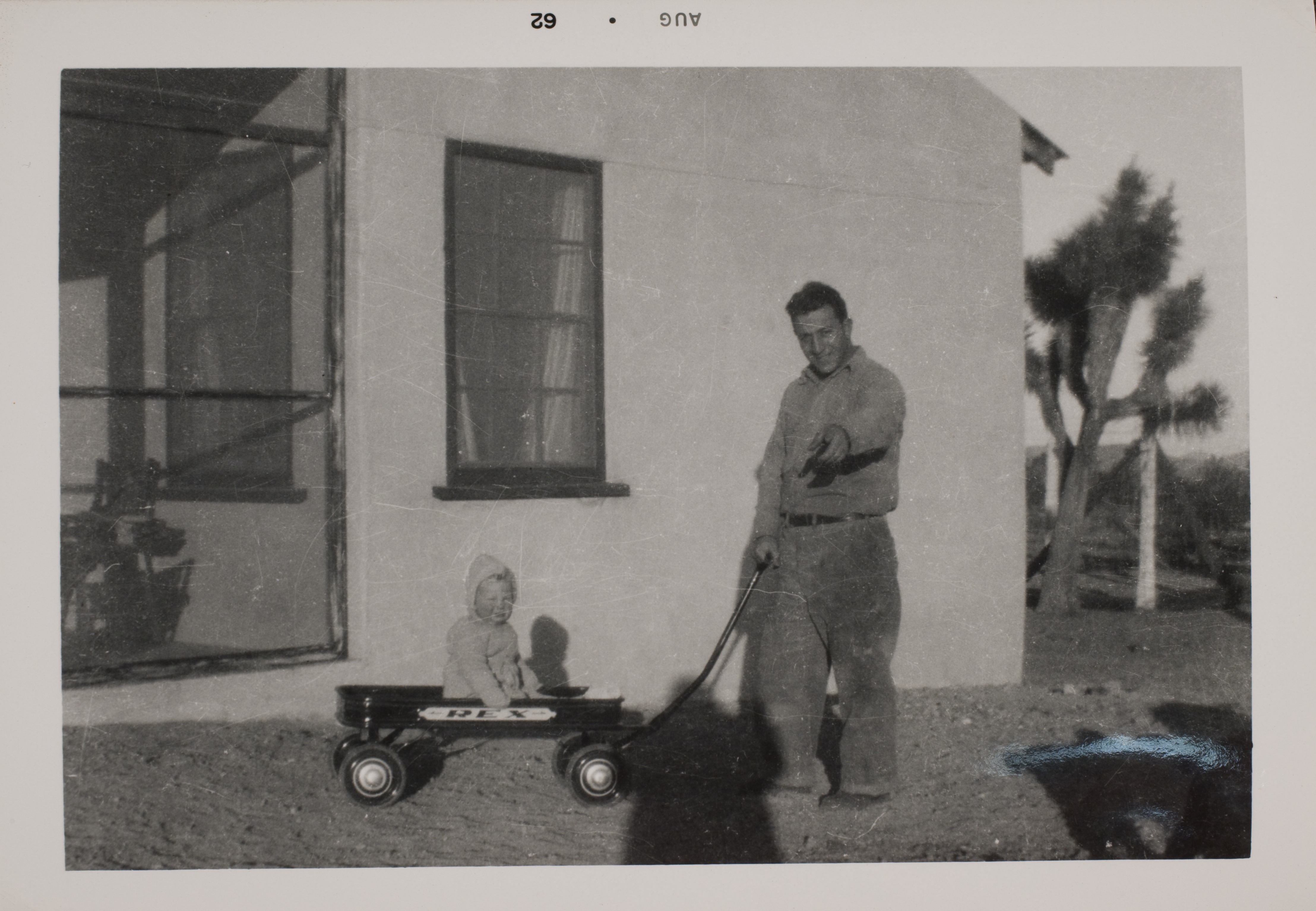 Rex Anthony Bell, Jr (Toni Larbow Beldam) in wagon with unidentified man by bunkhouse at Walking Box Ranch, Nevada: photographic print