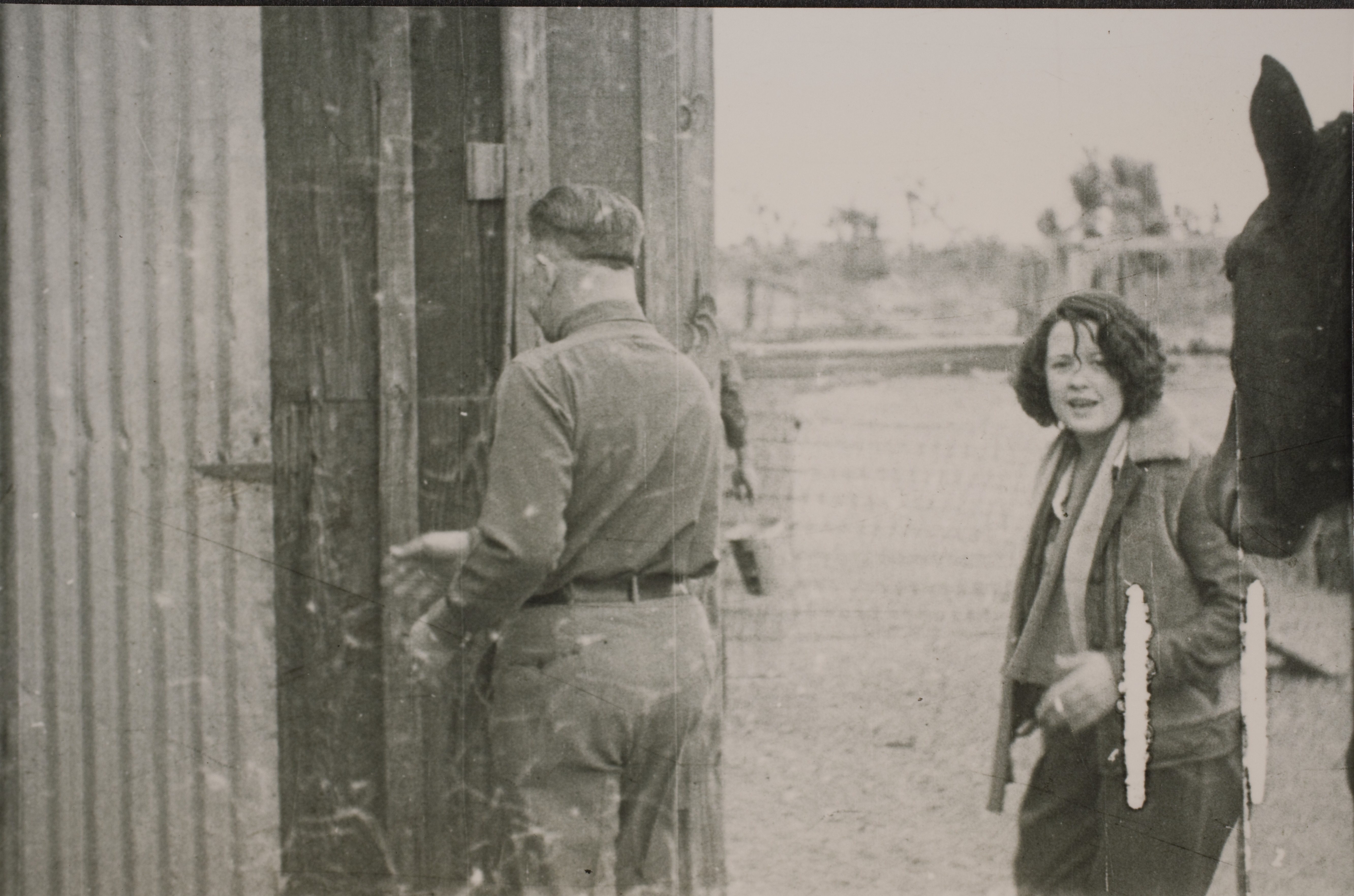 Unidentified man and woman with horse outside the barn at Walking Box Ranch: photographic print