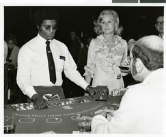Photograph of a blackjack dealer and a cocktail waitress at the Sands Hotel casino, Las Vegas, circa late 1960s