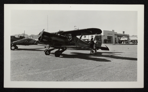 Photograph of two women standing in front of a propeller airplane, Boulder City, Nevada, circa 1930s-1940s