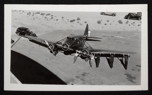 Photograph of men pushing a propeller airplane on an airfield, Boulder City, Nevada, circa 1930s
