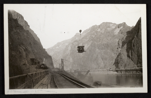 Photograph of cement mixer being lowered into Hoover Dam construction site, circa 1930-1935