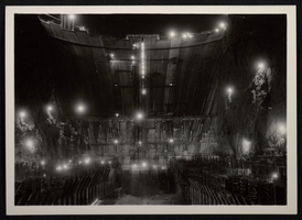 Photograph of Hoover Dam construction at night, seen from canyon floor, circa 1930-1935