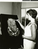 Photograph of artist Joy Caros painting a portrait, May 1963