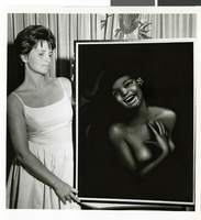 Photograph of artist Joy Caros with one of her paintings, May 1963