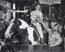 Photograph of a man sitting on a horse amid a group of people at a Union Pacific Old Timer's Club gathering at the Fremont Hotel, Las Vegas, circa 1940