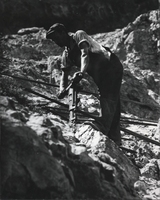Photograph of a man working construction on a cliff near Black Canyon, Nevada, circa 1931