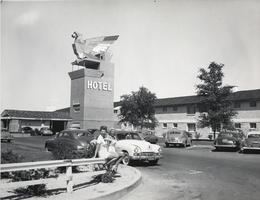 Photograph of two women posing near the front entrance of the Thunderbird Hotel, Las Vegas, circa 1950s