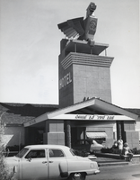 Photograph of two women posing near the front entrance of the Thunderbird Hotel, Las Vegas, circa 1950s