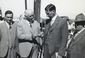 Photograph of Carl Gray handing Ray Lyman Wilbur the first railroad spur spike for Hoover Dam, circa early 1930s