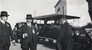 Photograph of men near a truck and building, early 1900s