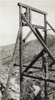 Photograph of a man on a large structure, circa early 1900s