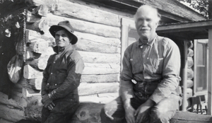 Photograph of men outside of log building, circa 1920s-1940s