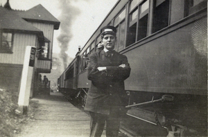 Photograph of train attendant and train, circa 1900-1930s