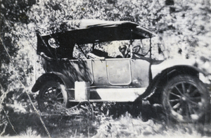 Photograph of car in unidentified wooded location, circa 1905-1912