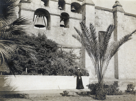 Photograph of woman in front of building, circa 1900-1920