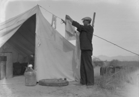 Film transparency of man hanging laundry, Las Vegas, 1931