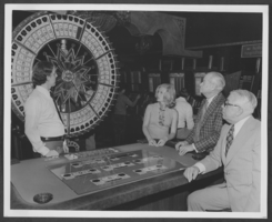 Photograph of gamblers at a wheel of fortune game in the Aladdin Hotel, Las Vegas, Nevada, circa early 1970s