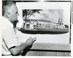 Photograph of Wilbur Clark with an artist's rendering of the Colonial House, Las Vegas, Nevada, circa early-mid 1950s