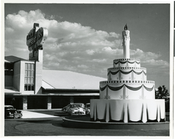 Photograph of an oversized birthday cake replica in front of the Desert Inn, Las Vegas, Nevada, April 1951