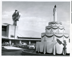 Photograph of an oversized birthday cake replica in front of the Desert Inn, Las Vegas, Nevada, April 1951