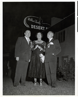 Photograph of Tommy and Helen McGinty with Wilbur Clark outside of the Desert Inn Hotel, Las Vegas, Nevada, April 1951