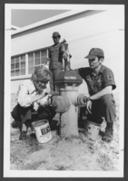 Photograph of First Lieutenant Linda Horton and Master Sergeant Reggie Wise painting a hydrant for a bicentennial celebration, Nellis Air Force Base, Nevada, February 23, 1976