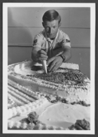 Photograph of Staff Sargeant Dan Oviatt decorating a cake for a U.S. bicentennial tribute, Nellis Air Force Base, Nevada, July 22, 1976