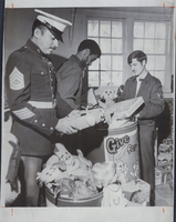 Photograph of military personnel with Toys for Tots donations, Nellis Air Force Base, Nevada, December 25, 1977