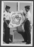 Photograph of airmen unfurling Nevada's bicentennial flag at Nellis Air Force Base, Nevada, September 24, 1975