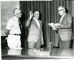 Photograph of Ray Daines taking an oath of office before Mayor Gene Echols and Bud Cleland, North Las Vegas, Nevada, circa 1976