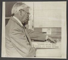 Photograph of Ted Travers, North Las Vegas Chamber of Commerce President, with a new bumper sticker promoting the city, North Las Vegas, Nevada, March 31, 1976