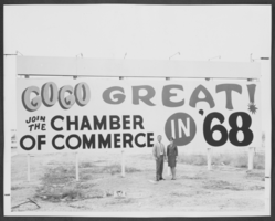 Photograph of people standing in front of a billboard promoting membership in the North Las Vegas Chamber of Commerce, North Las Vegas, Nevada, 1968