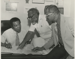 Photograph of men studying the NAACP Senior Housing Complex, unknown location, July 10, 1979