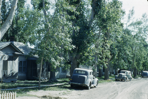 Photograph of cars and a house, location unknown, circa 1940s