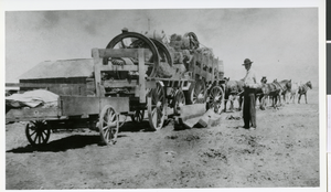 Photograph of Ed Von Tobel, Sr. inpsecting the loading of a wagon carrying supplies to the Bullfrog Mining District, Las Vegas, circa 1904-1915