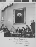 Photograph of eight men seated under a portrait of George Washington, 1967