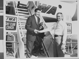 Photograph of Mayor Oran K. Gragson greeting Lawrence Welk as he deplanes after a TWA flight, circa 1960s