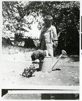 Photograph of a young Indian boy with a puppy in a watering can, Pahrump Valley, Nevada, circa 1880s-1890s