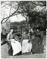 Photograph of a Paiute or Shoshone woman and two Anglo women seated on wicker chairs, possibly at Manse Ranch, Pahrump, Nevada, circa 1900s-1910s