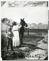 Photograph of "Jane Beatty" petting a horse, Ash Meadows, Pahrump, Nevada, circa 1900s-1910s