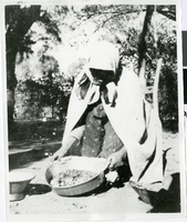 Photograph of an Indian woman displaying the contents of a shallow cooking pan, Manse Ranch, Pahrump Valley, Nevada, circa 1880s-1910s