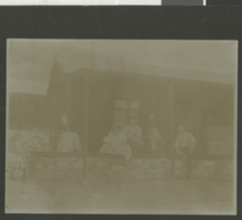 Photograph of men and women on porch, circa early 1900s