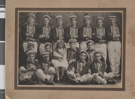 Photograph of a group of young men in uniforms with a girl dressed for Decoration Day, May 30, 1911, Tonopah, Nevada