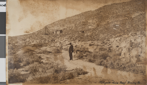Photograph of a man standing near the Gold Reef Minining Company operations, Tonopah, Nevada, circa July 1918