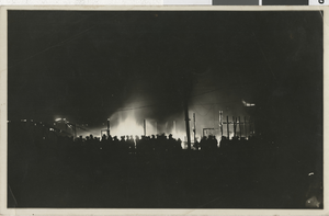 Photograph of a crowd of people watching a nighttime fire, probably in Nevada, circa 1900s